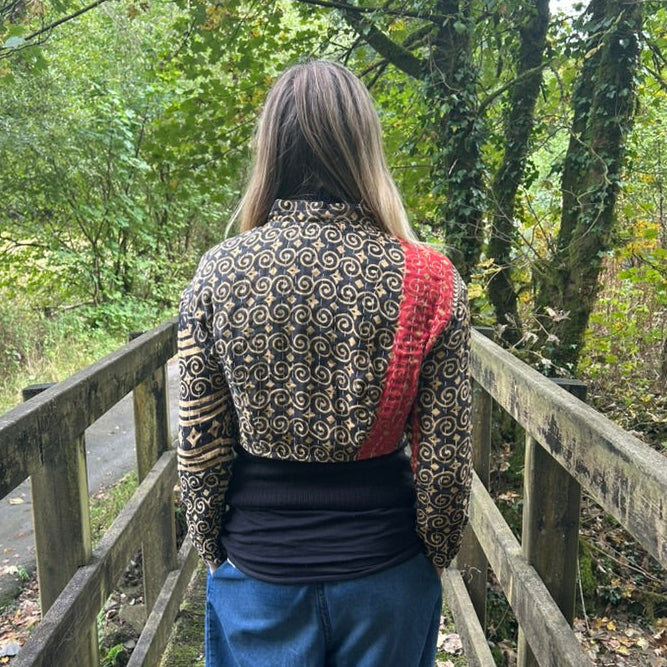 Back view of black and ochre reclaimed cotton Gudri jacket with kantha stitching and contrasting red panel.