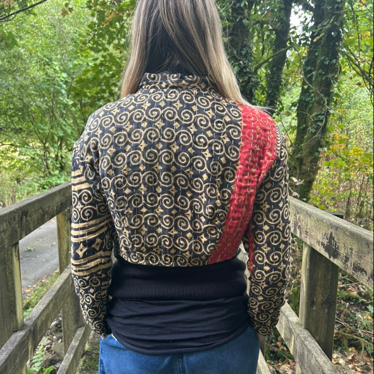 Back view of black and ochre reclaimed cotton Gudri jacket with kantha stitching and contrasting red panel.