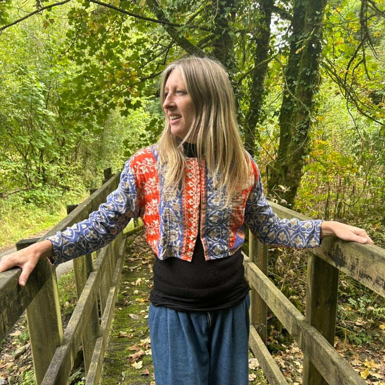 Woman wearing the Saffron Sky Gudri Jacket in red, cobalt blue and cream reclaimed cotton with kantha stitching