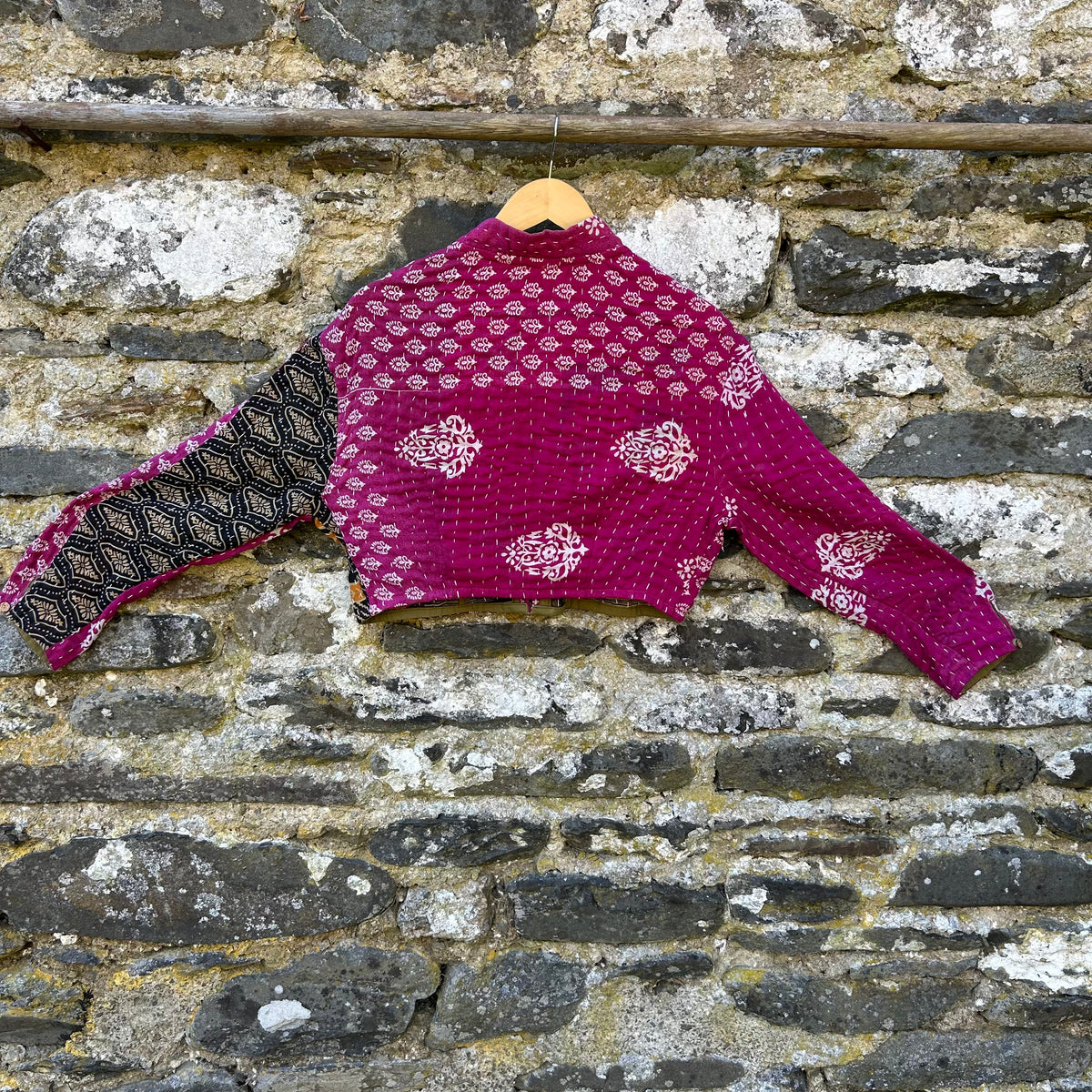 Back view of pink Gudri kantha jacket made from reclaimed cotton, with contrasting patterned sleeve and visible running stitch