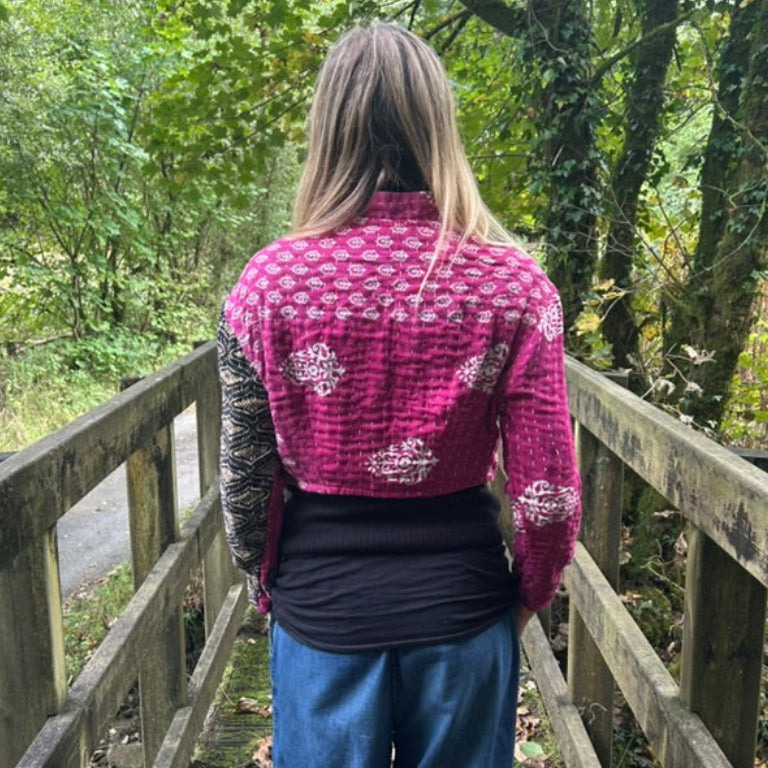 Woman wearing pink reclaimed cotton Gudri jacket with traditional kantha stitching, back view