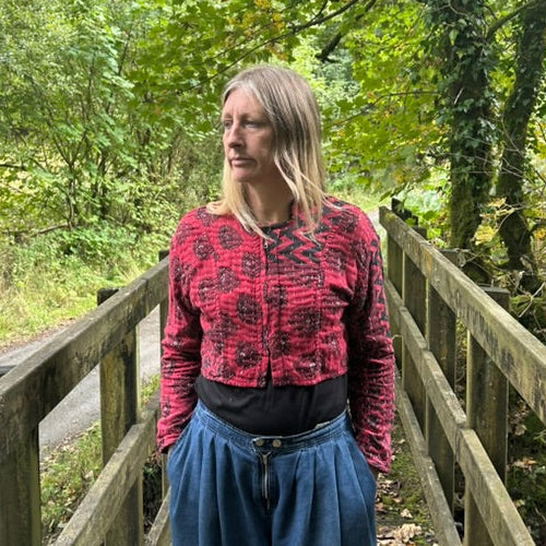 Woman wearing the red and black Crimson Trail Gudri jacket with kantha stitching and cropped zip-front design