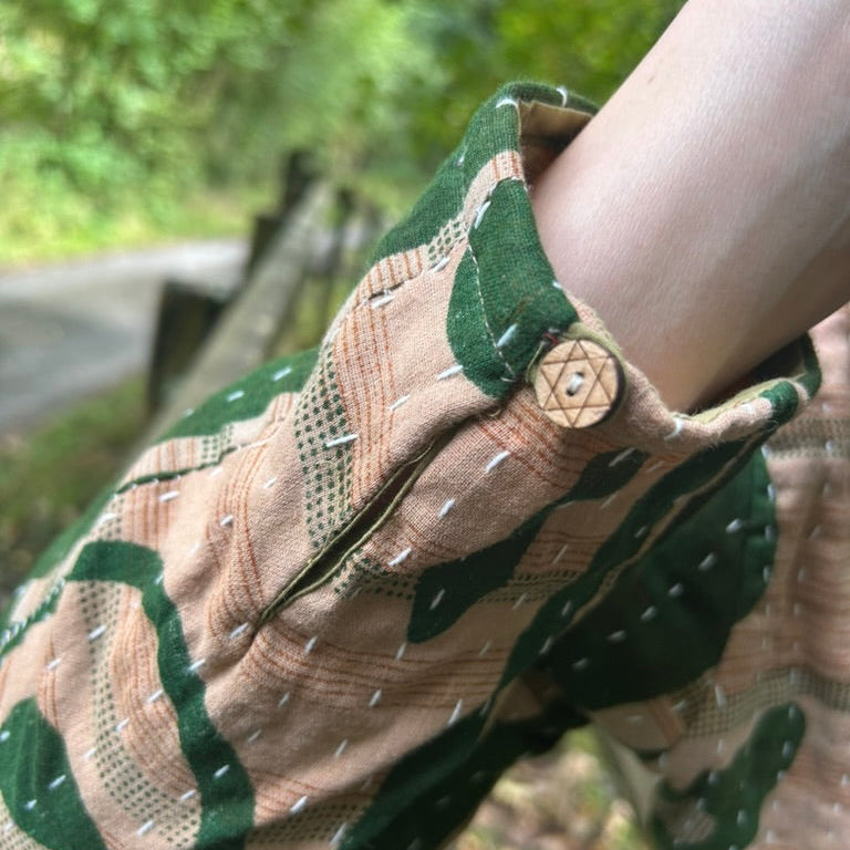 Close-up of Forest Bloom green and stone Gudri jacket showing kantha stitching and wooden cuff button